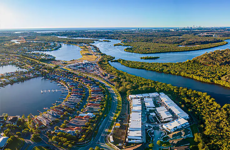 Aerial view over the Serenity 4212 estate, its lake and canals, with the Gold Coast skyline beyond